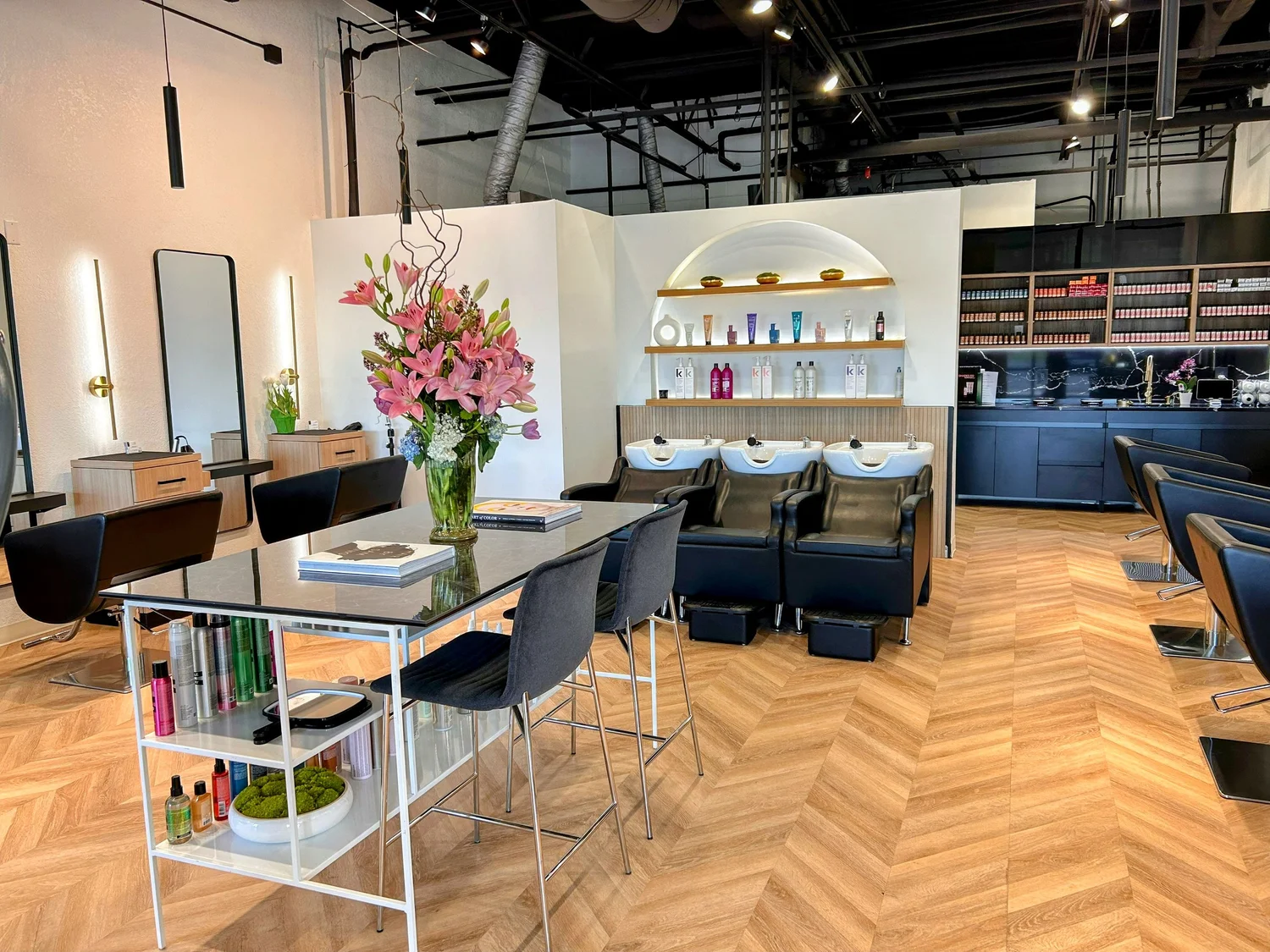 Hair styling area with chairs, sinks and shelves of products