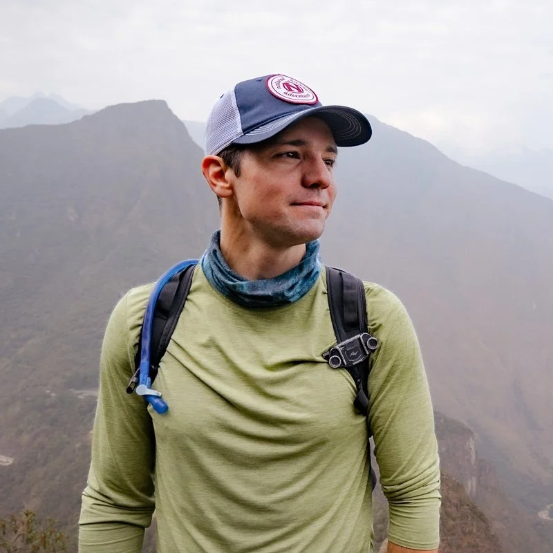 Handsome man standing in front of foggy mountain.