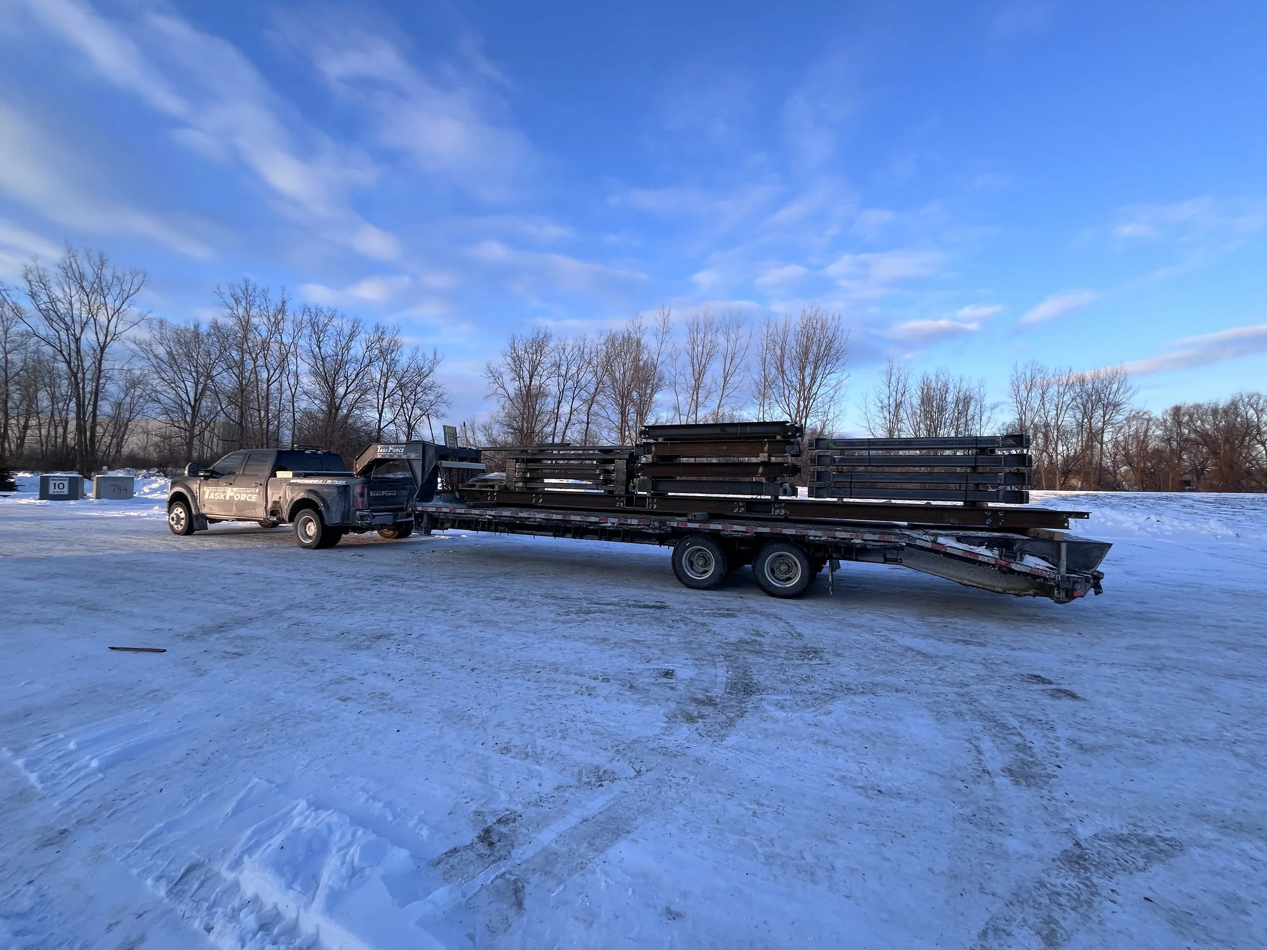 Task Force Transport & Logistics Ford F-450 hotshot truck transporting commercial cargo on a gooseneck flatbed trailer in Ontario, Canada.