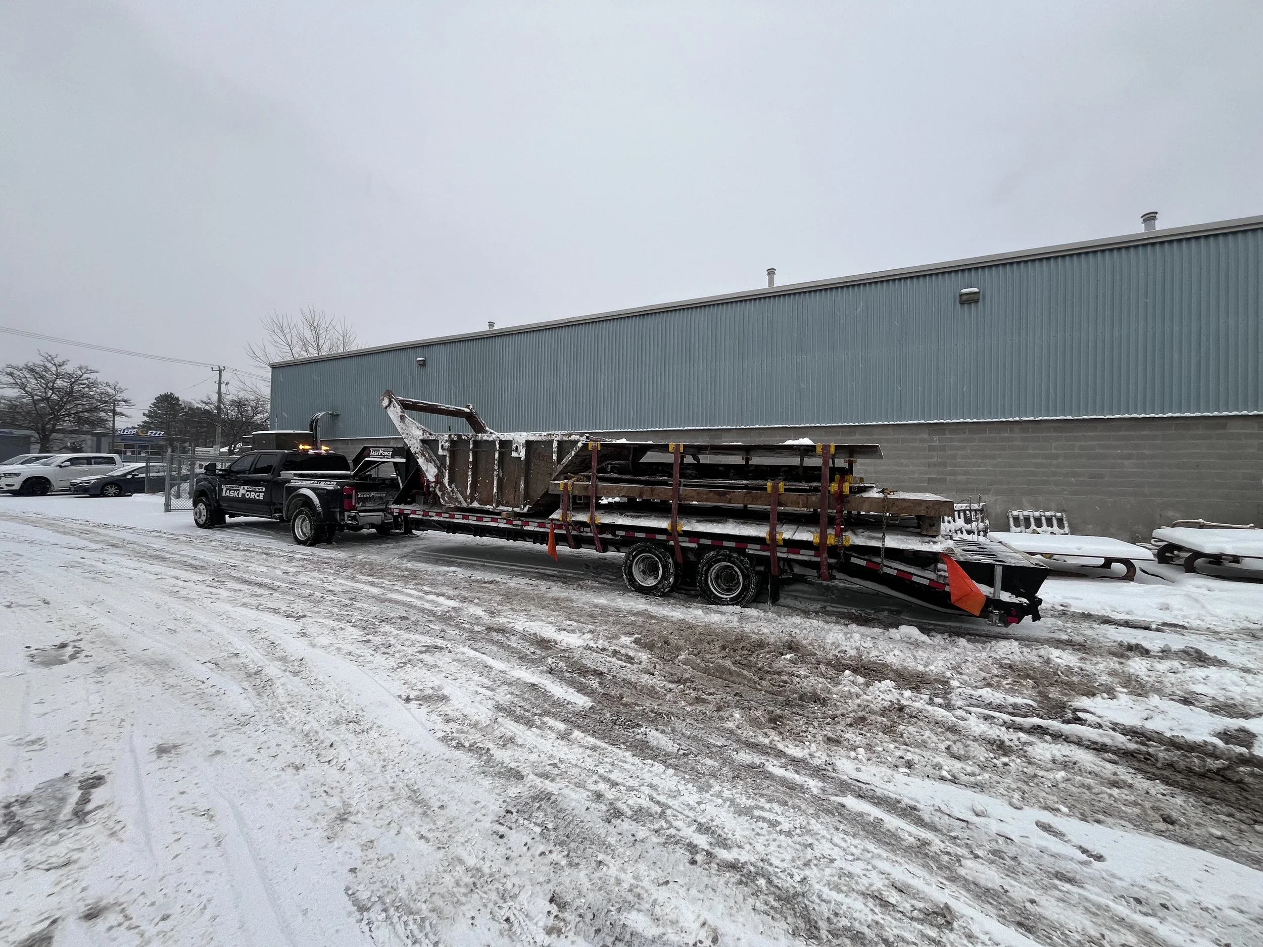 Task Force Transport & Logistics Ford F-450 hotshot truck transporting oversize cargo on a gooseneck flatbed trailer in Ontario, Canada.
