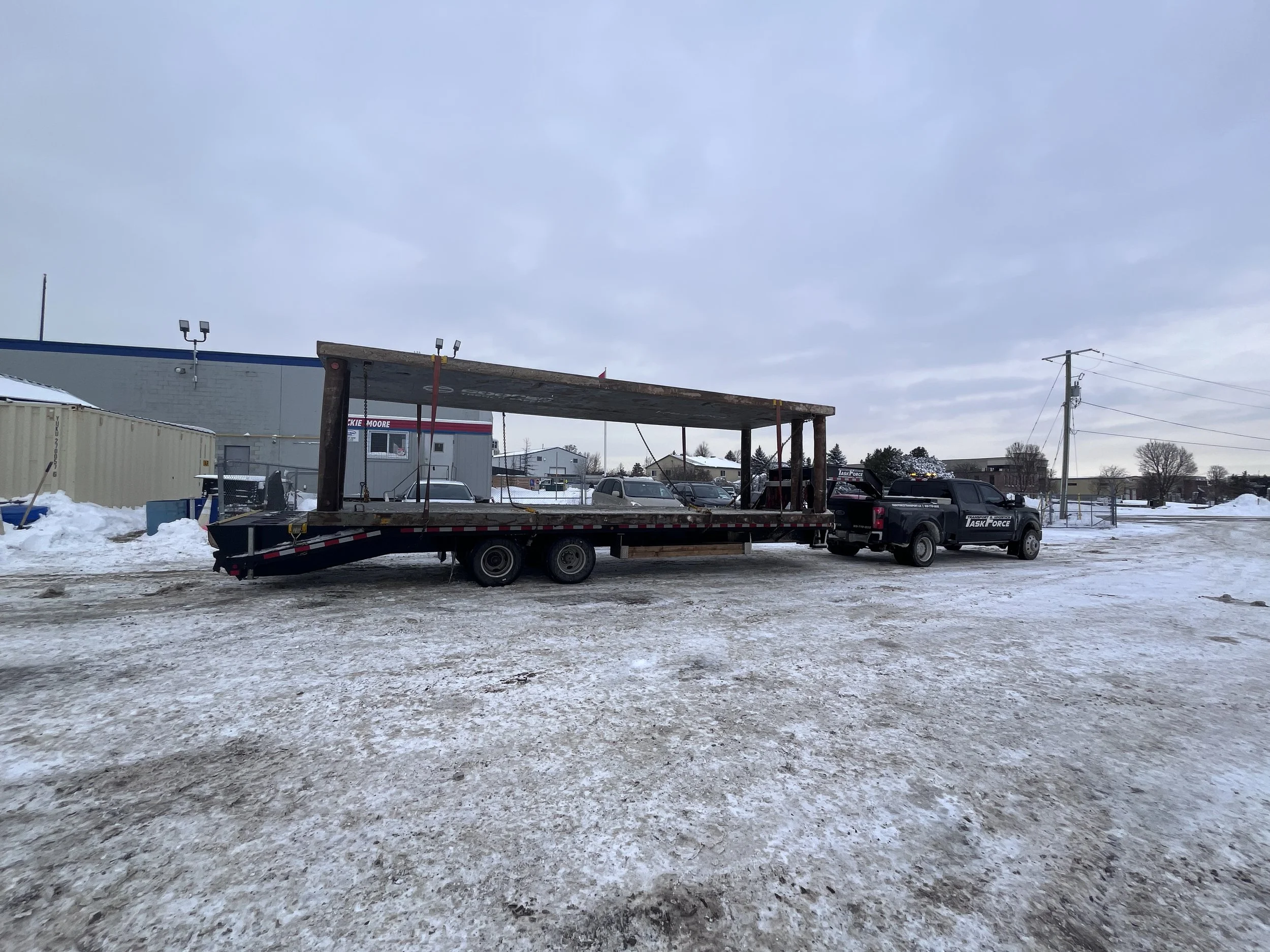 Task Force Transport & Logistics Ford F-450 hotshot truck transporting oversize cargo on a gooseneck flatbed trailer in Ontario, Canada.