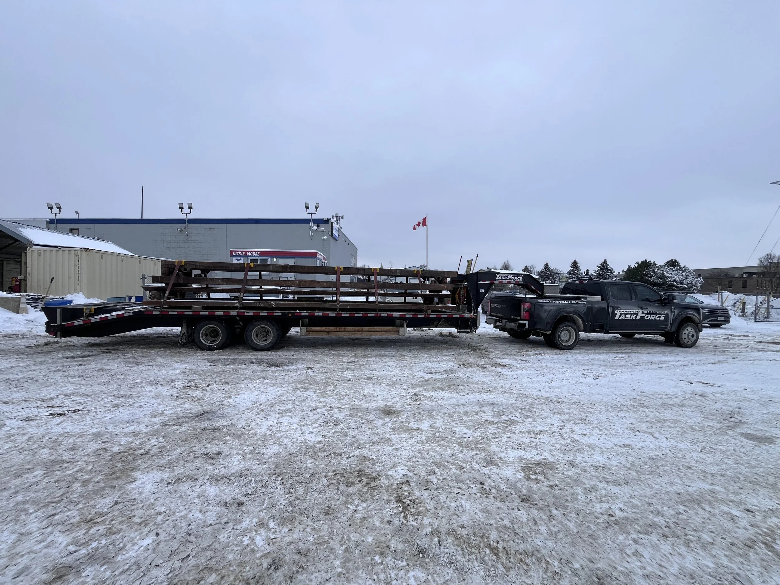 Task Force Transport & Logistics Ford F-450 hotshot truck transporting commercial cargo on a gooseneck flatbed trailer in Ontario, Canada.