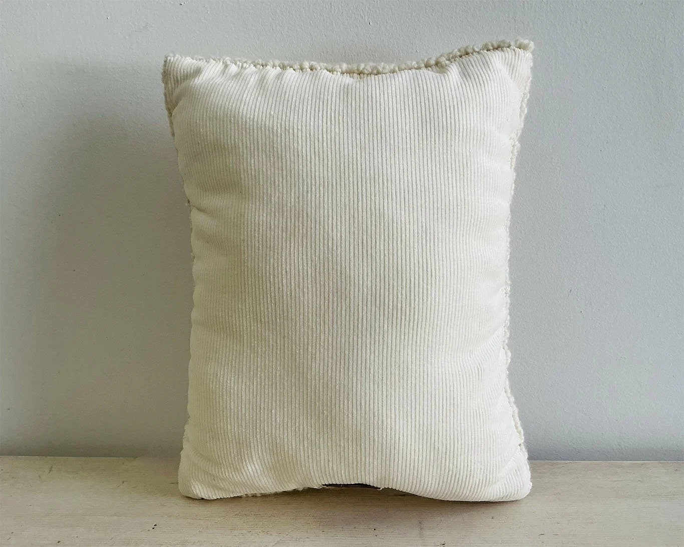 Back of pillow in ivory cotton corduroy fabric.