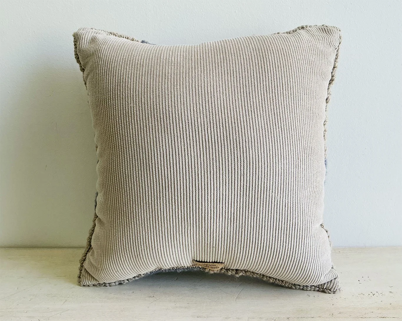 Back of pillow in natural cotton corduroy fabric.