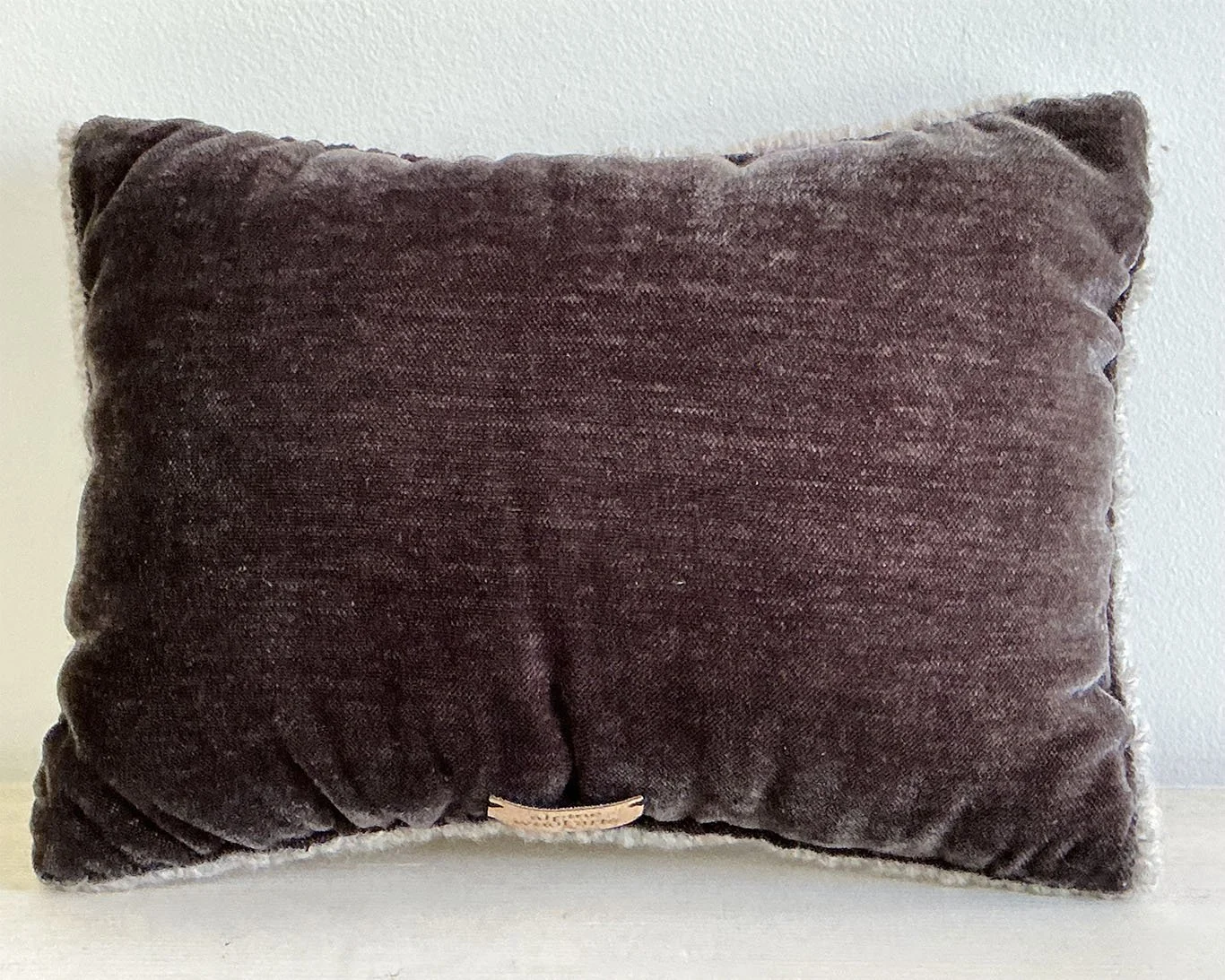 Back of pillow in brown cotton fabric.