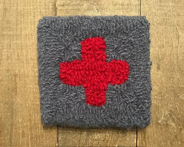 Hand-hooked wool panel in slate featuring centered red cross in square format.
