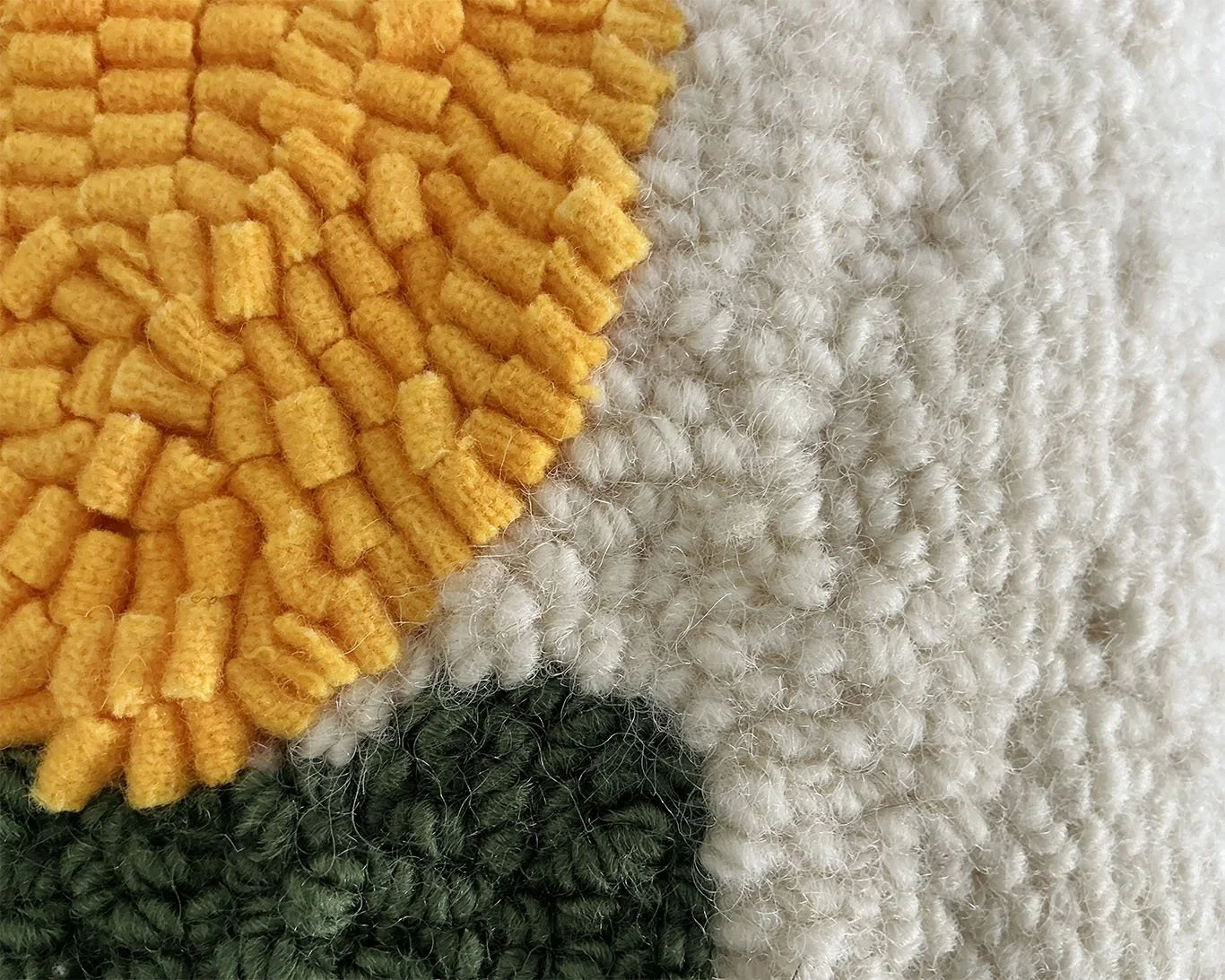 Detail of hand-hooked wool forming the stylized alpine flower motif.