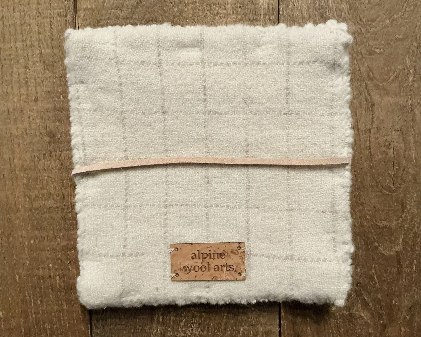 Back of hand-hooked wool panel in red and ivory, showing finished ivory wool backing.