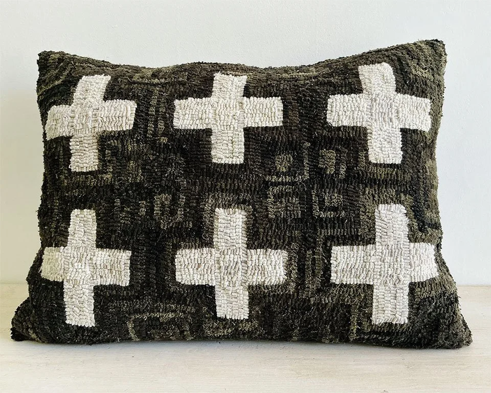 Mottled black hand-hooked wool pillow with ivory Nordic cross motifs.