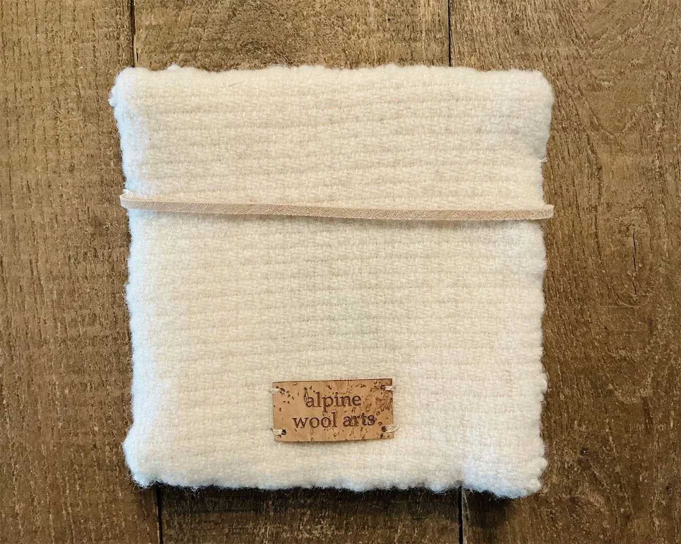 Back of hand-hooked wool panel in ivory wool, showing finished ivory wool backing.
