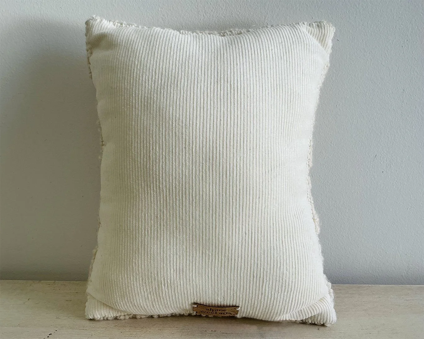 Back of pillow in ivory cotton corduroy fabric.
