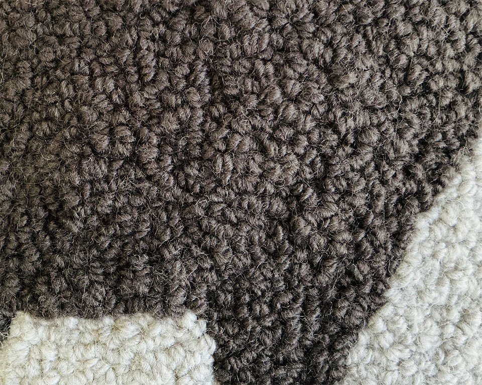 Detail of hand-hooked wool showing the moos against the natural ground.