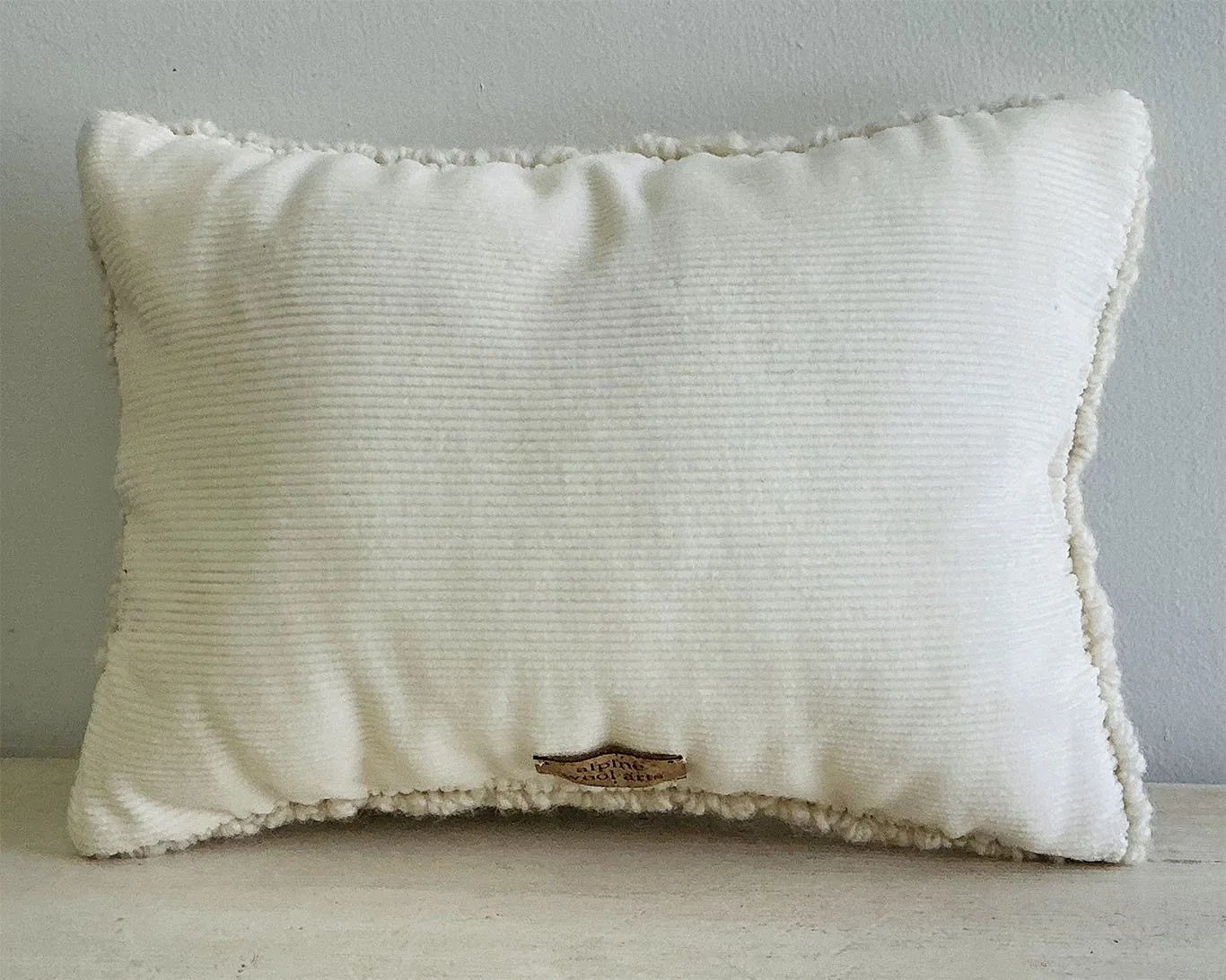 Back of pillow in ivory cotton corduroy fabric.