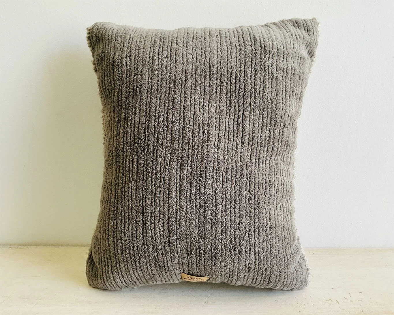 Back of pillow in gray cotton corduroy fabric.