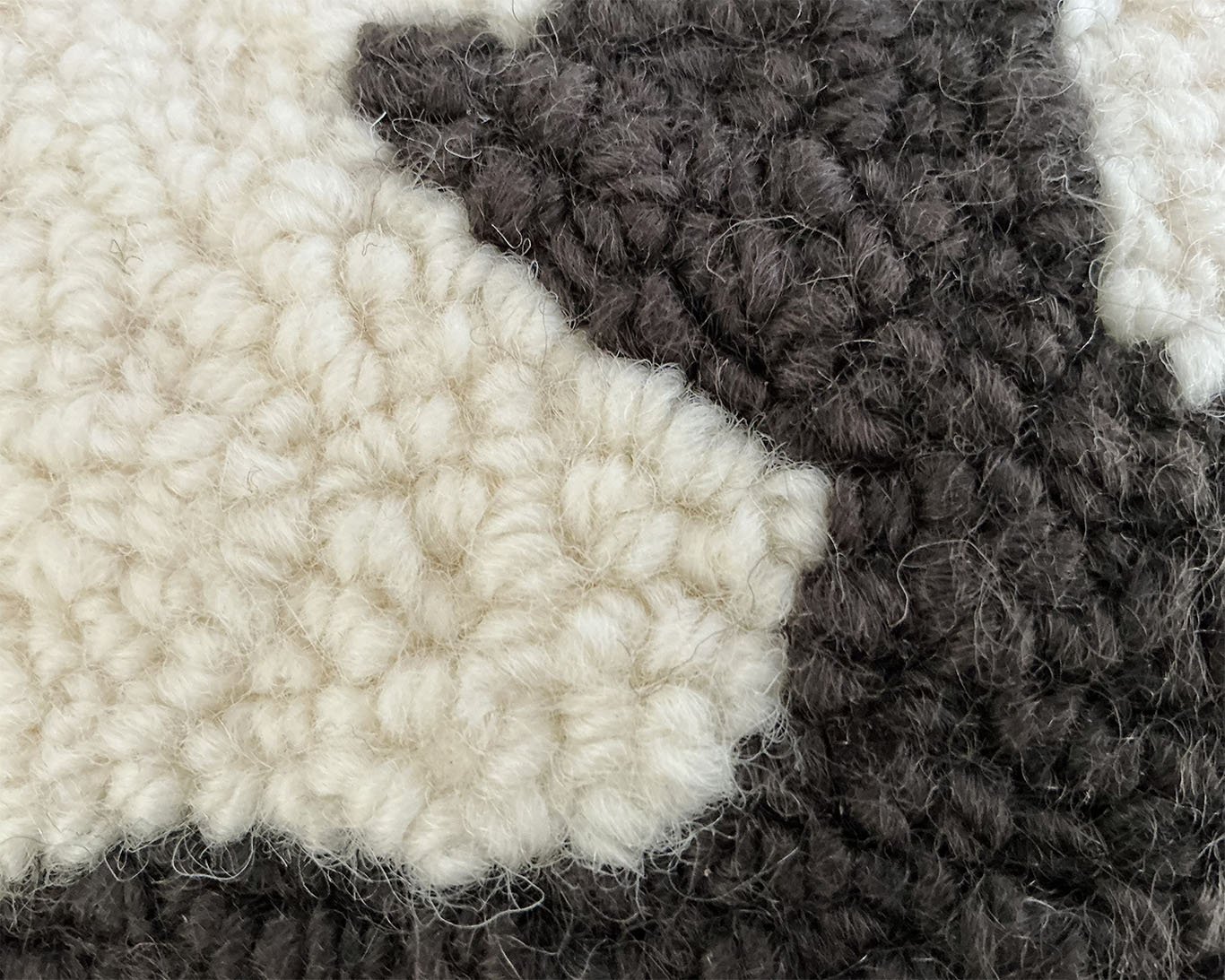 Detail of hand-hooked wool showing the moose against the ivory ground.