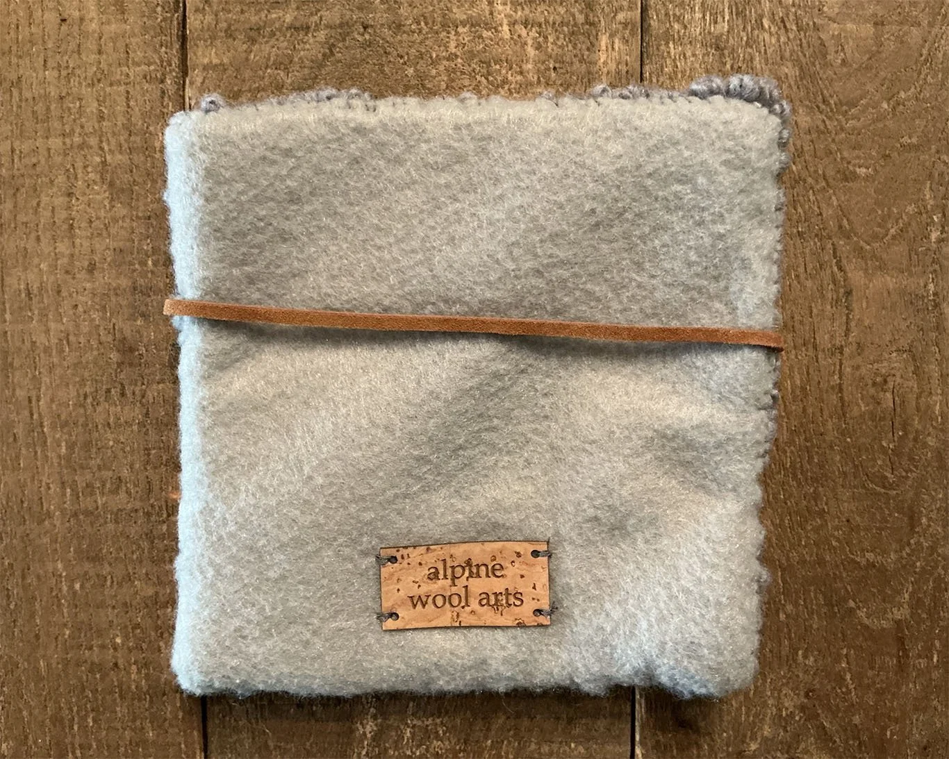 Back of hand-hooked wool panel in granite, bright pink, and green, showing finished gray wool.