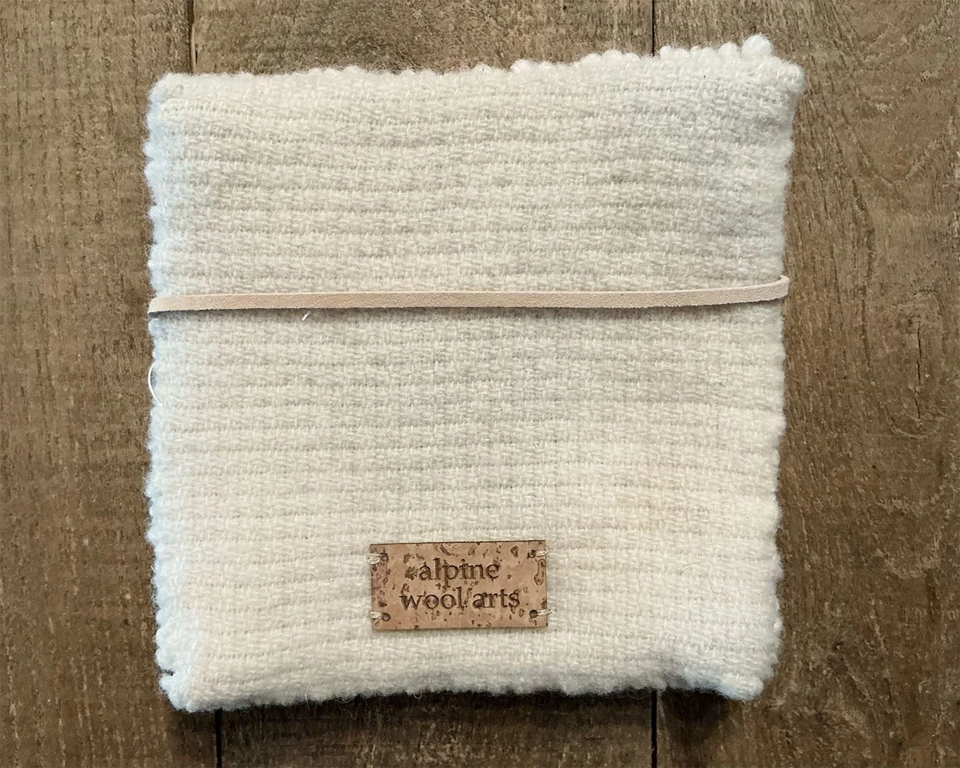 Back of hand-hooked wool panel in ivory, showing finished wool backing.
