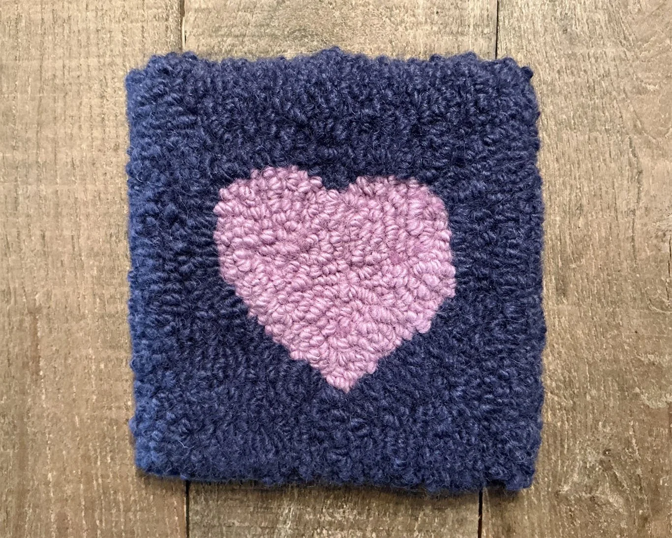 Hand-hooked wool panel in indigo featuring centered pink heart.