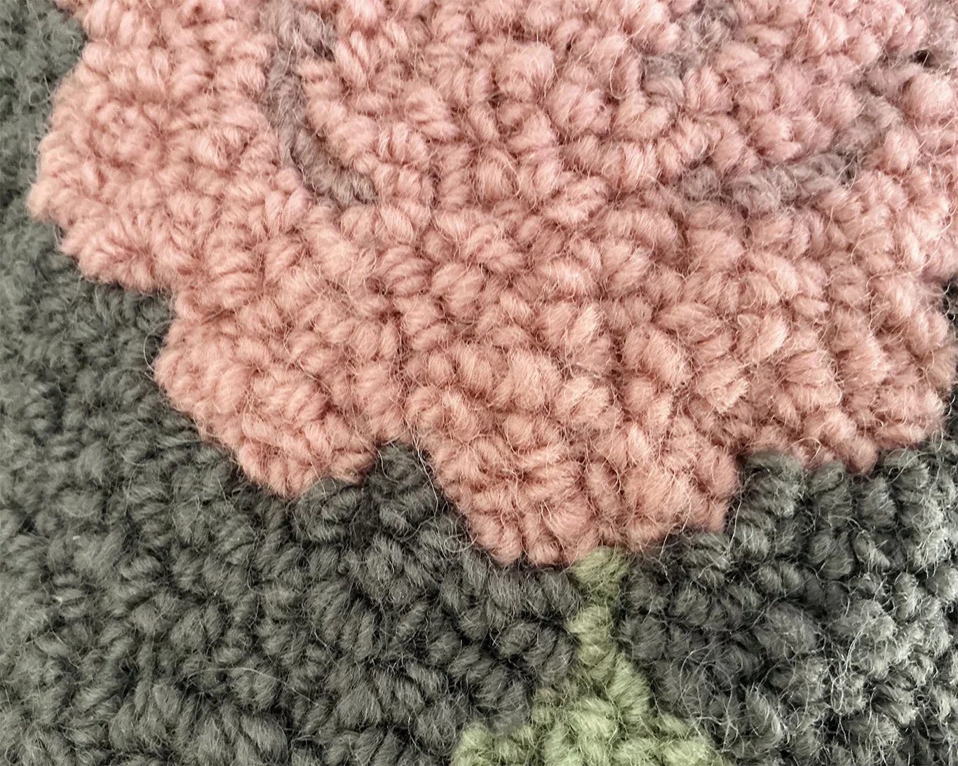 Detail of hand-hooked wool forming the stylized alpine flower motif.