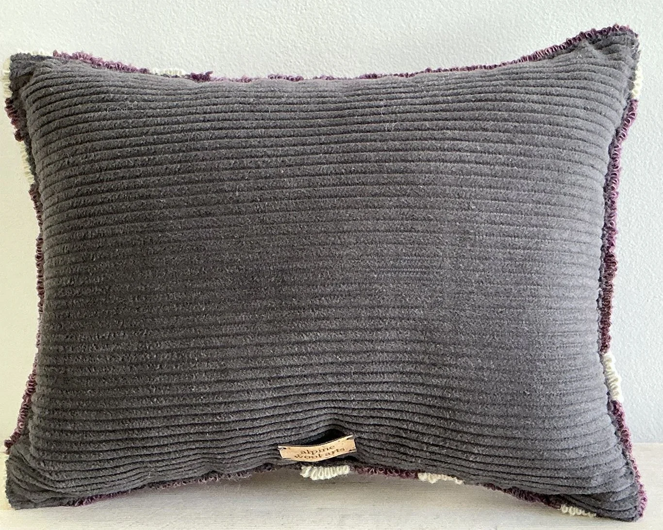 Back of pillow in charcoal cotton corduroy fabric.