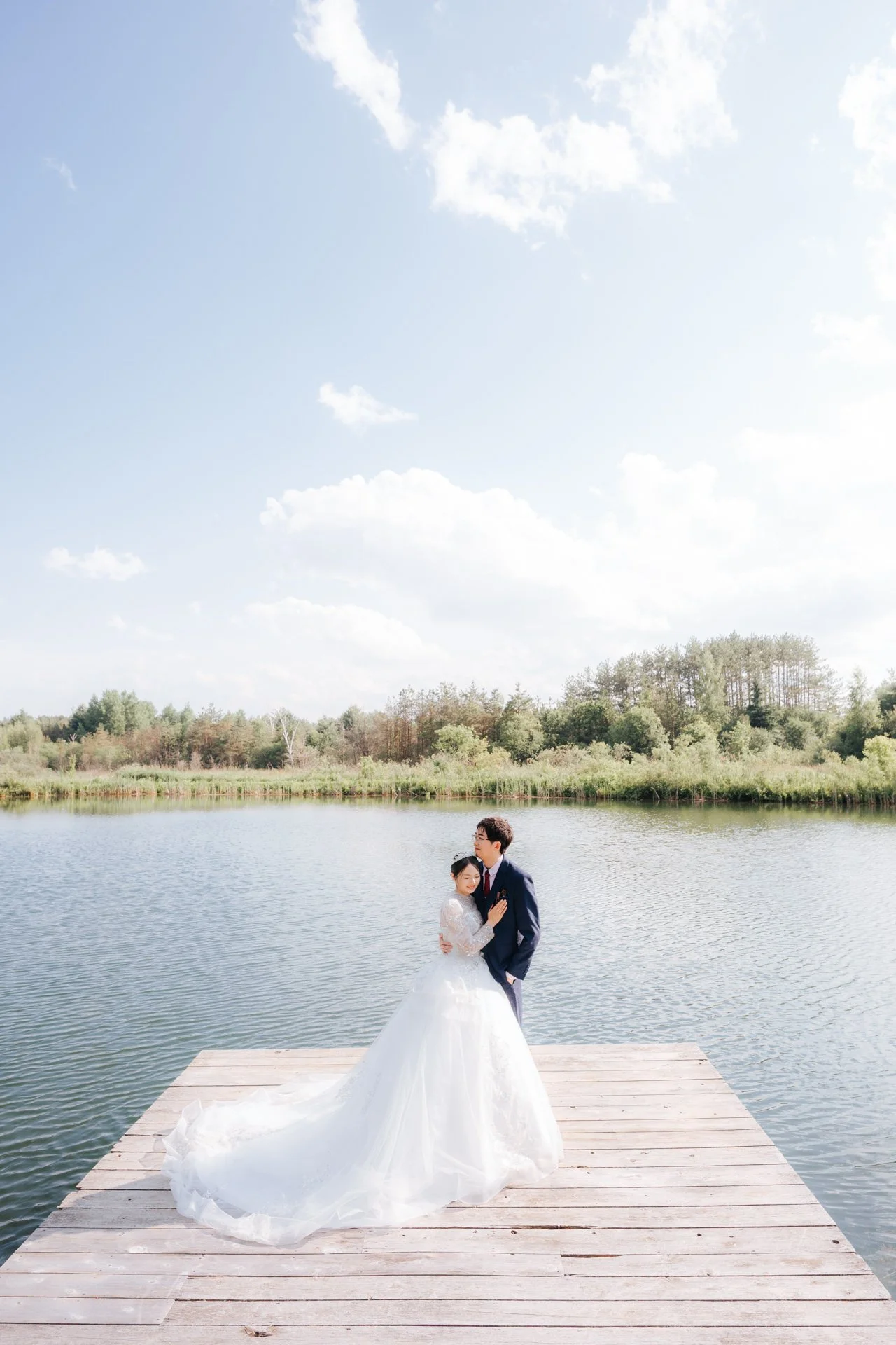 Bride and groom embracing on a wooden dock over the water at Royal Ashburn Golf Club.