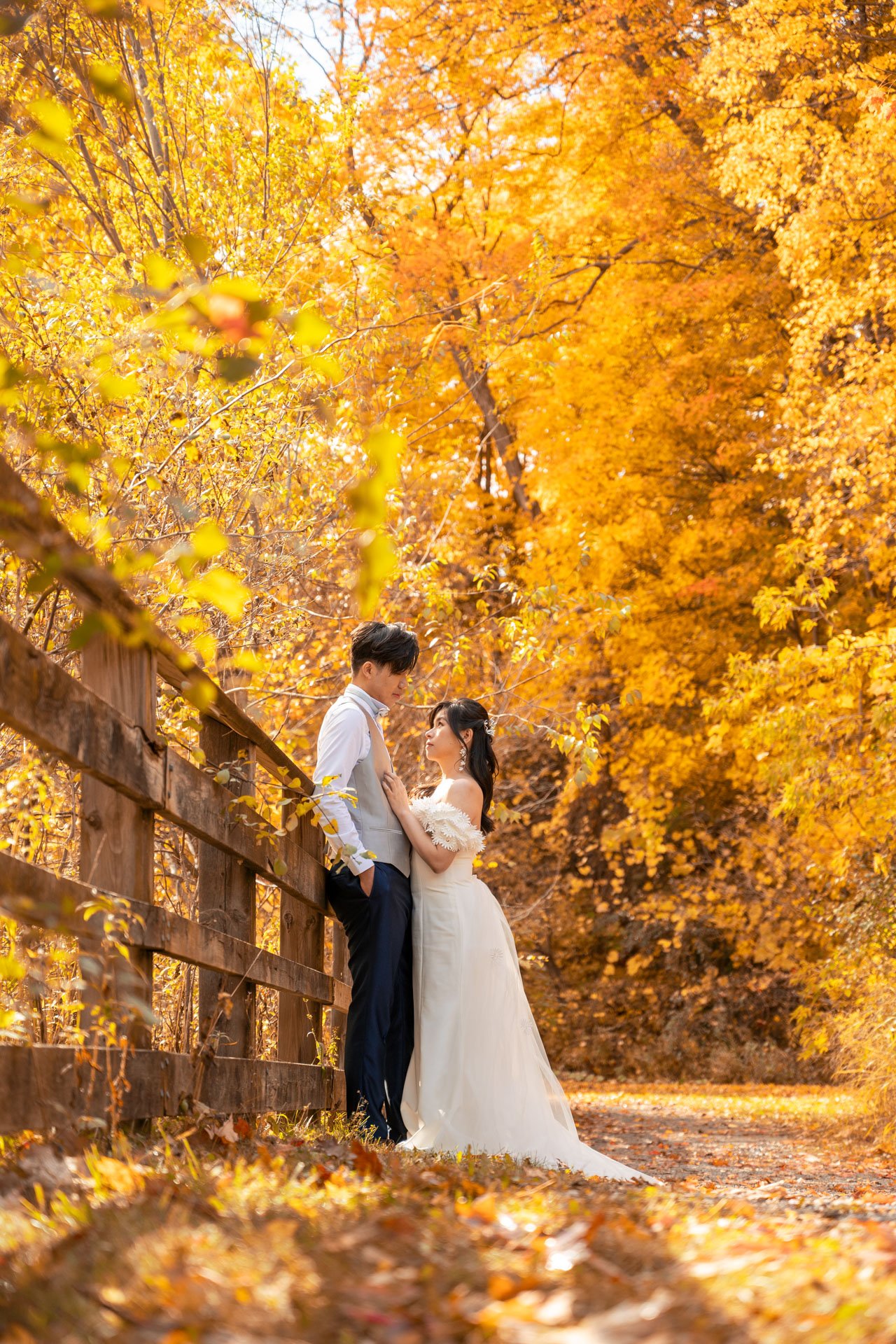Couple leaning against the wooden fence
