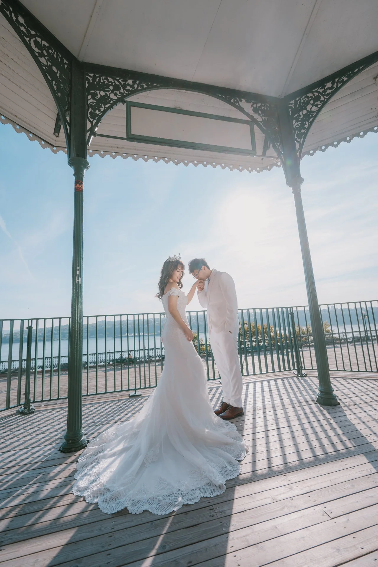 Groom kissing bride's hand inside the gazebo