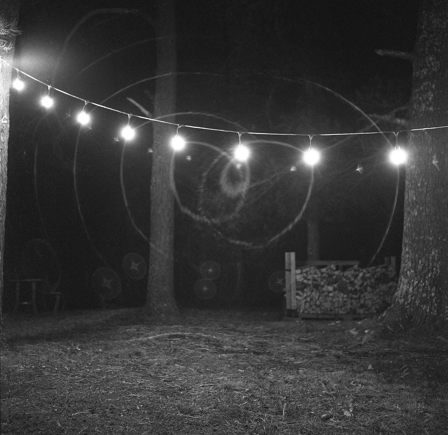String lights hanging from a cabin at night.