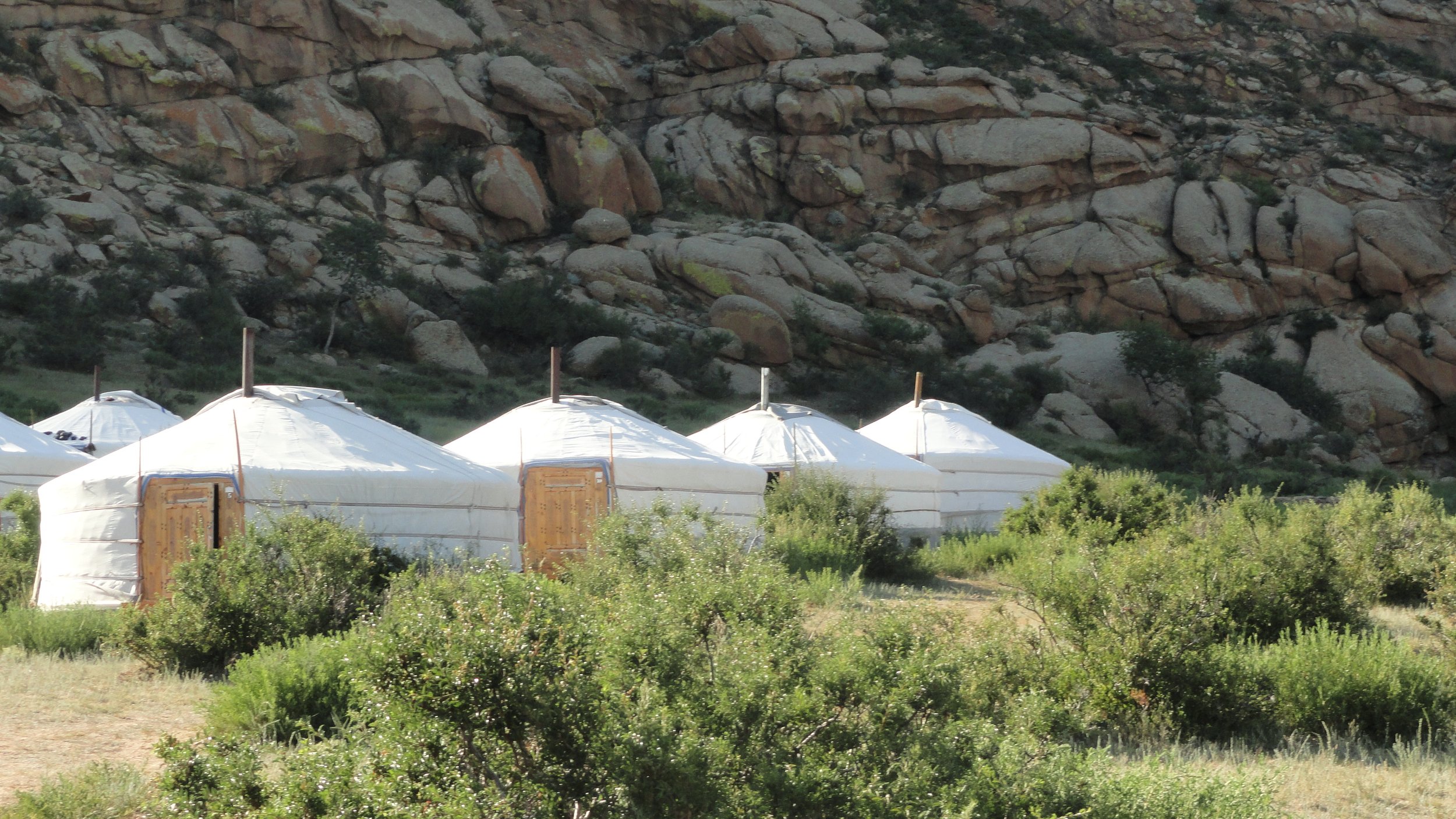 Traditional Mongolian Ger camp at the foot of a rocky mountain