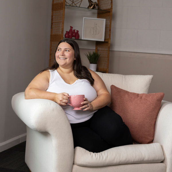 jess fry therapist sitting on a couch smiling looking out a window