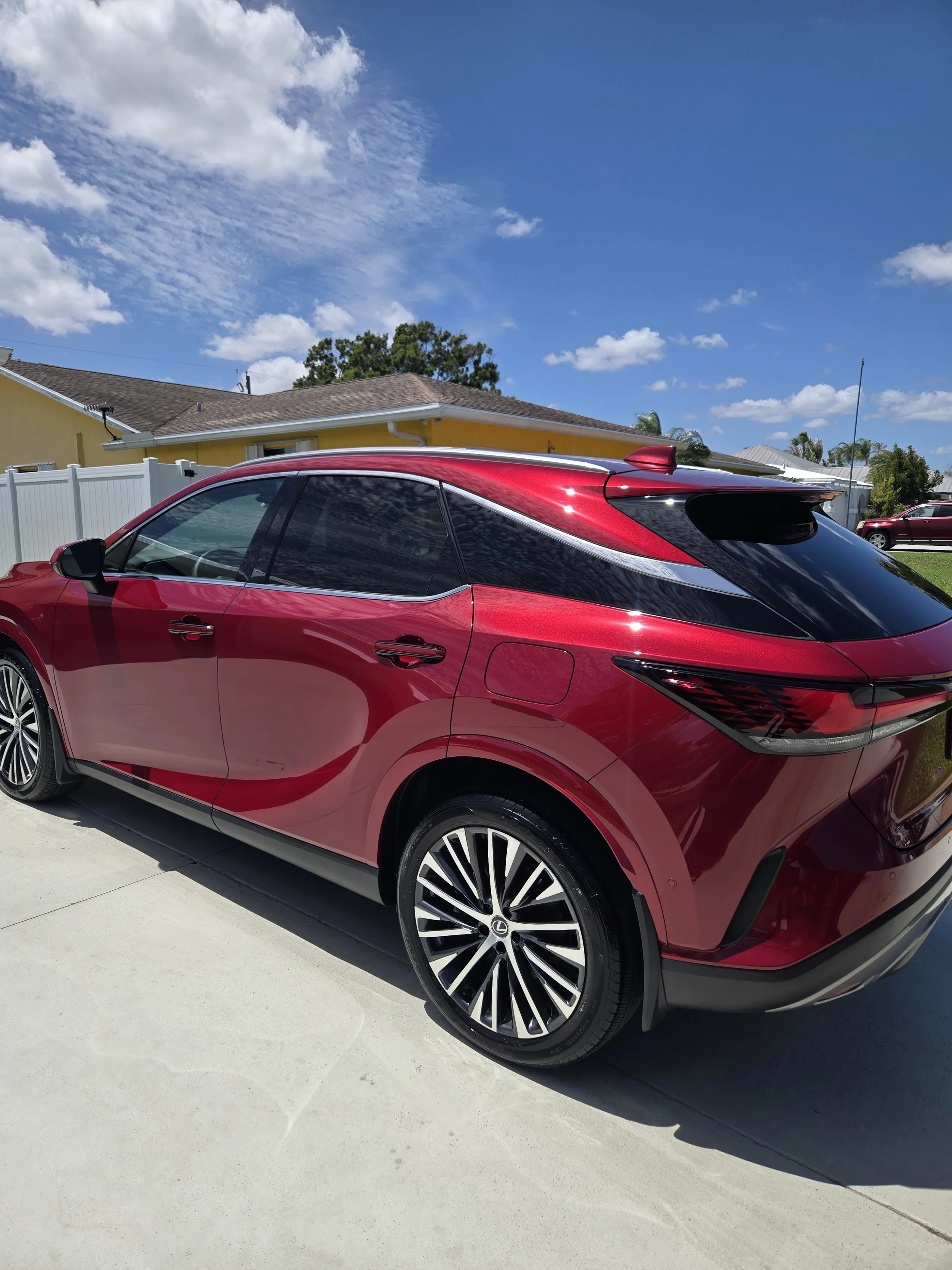 A red modern hatchback car getting detailed by wash boss mobile detailing.