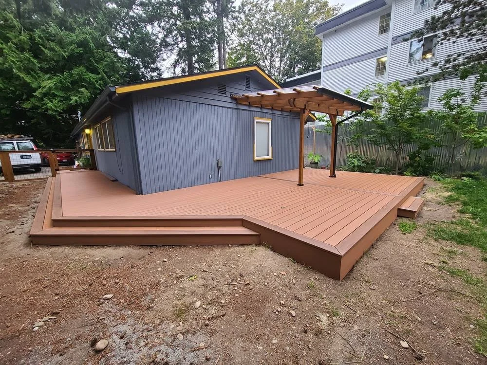 Backyard TimberTech PVC deck with wraparound walkway, picture-frame border and transparent patio cover