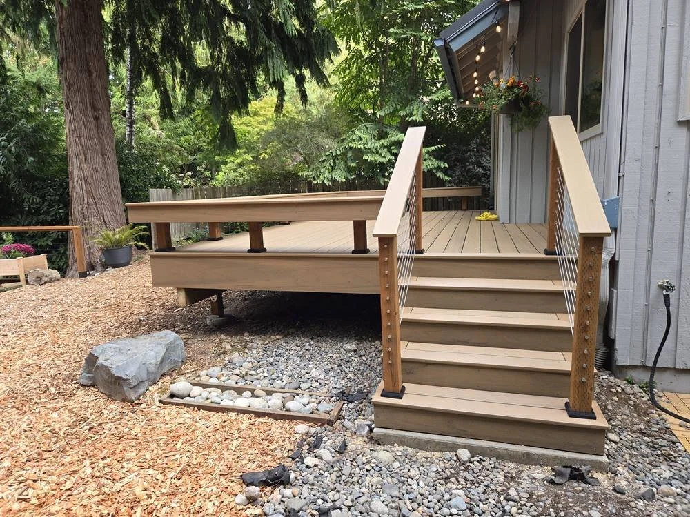 Edmonds backyard composite deck and stairs with cable railing beside a large tree