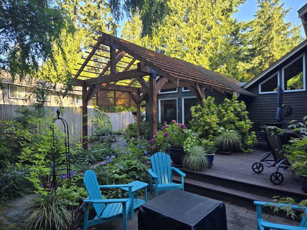 Edmonds timber frame pergola with privacy screen and black hardware over a backyard deck and garden