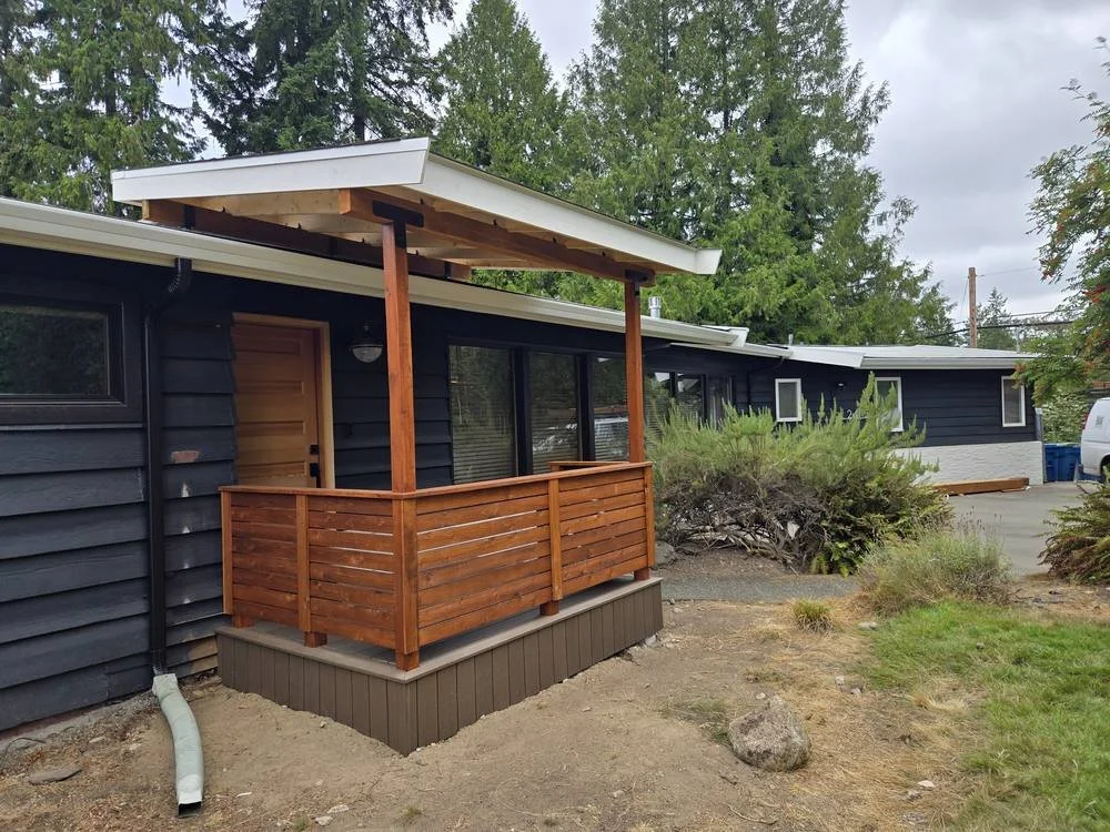 Front porch cover with cedar posts and horizontal railing built to match the existing fence