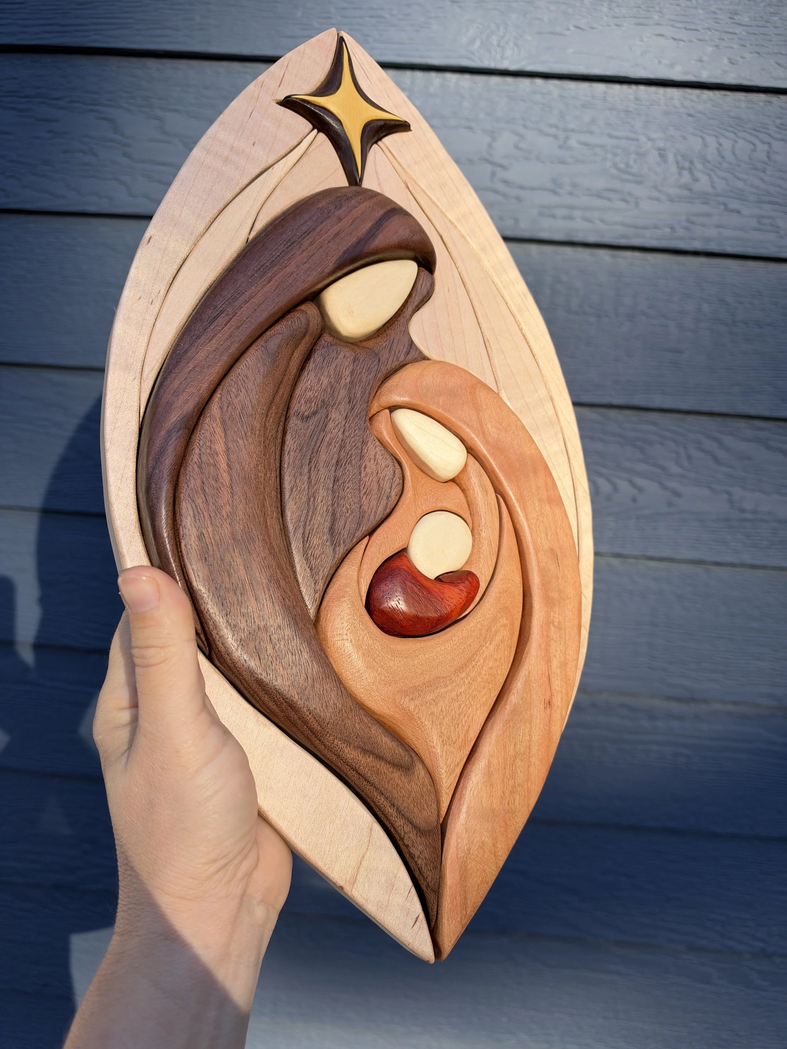 Wooden Holy Family scene with flowing curved outlines