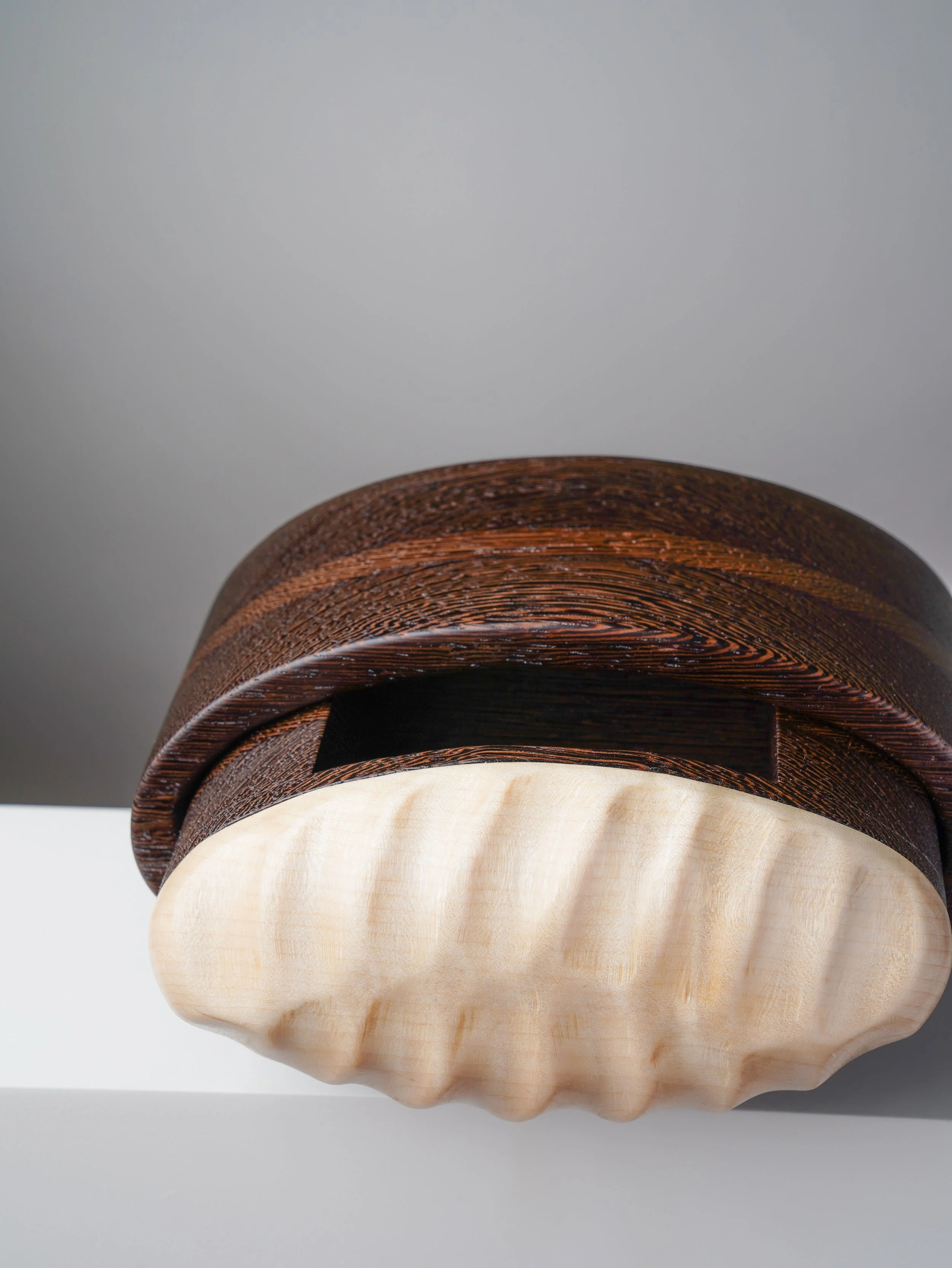 Hand-carved curly maple detail on a wenge bandsaw box.