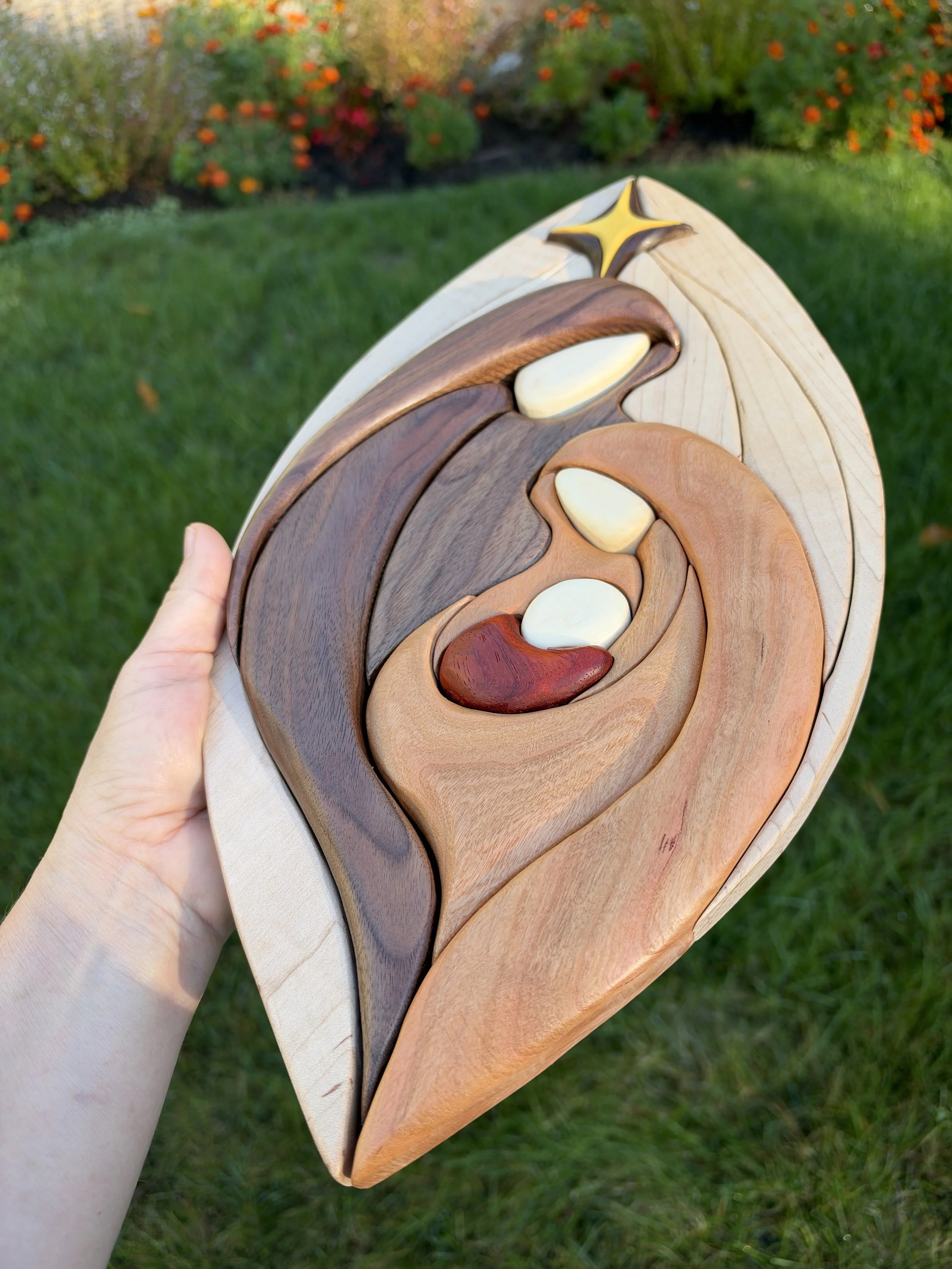 Angled view of the wooden nativity wall hanging held outdoors