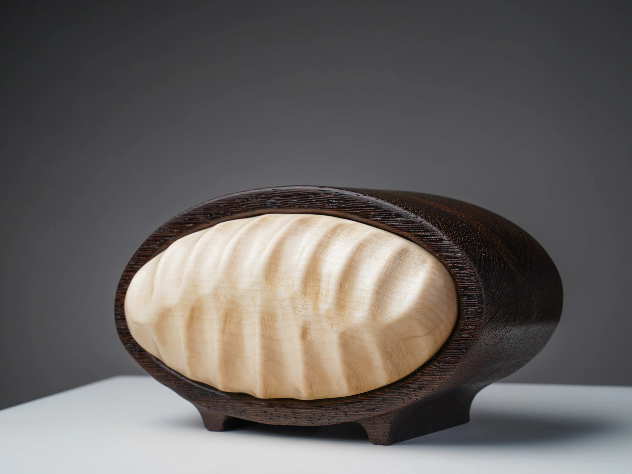 Front view showing the curved maple carving and wenge frame.