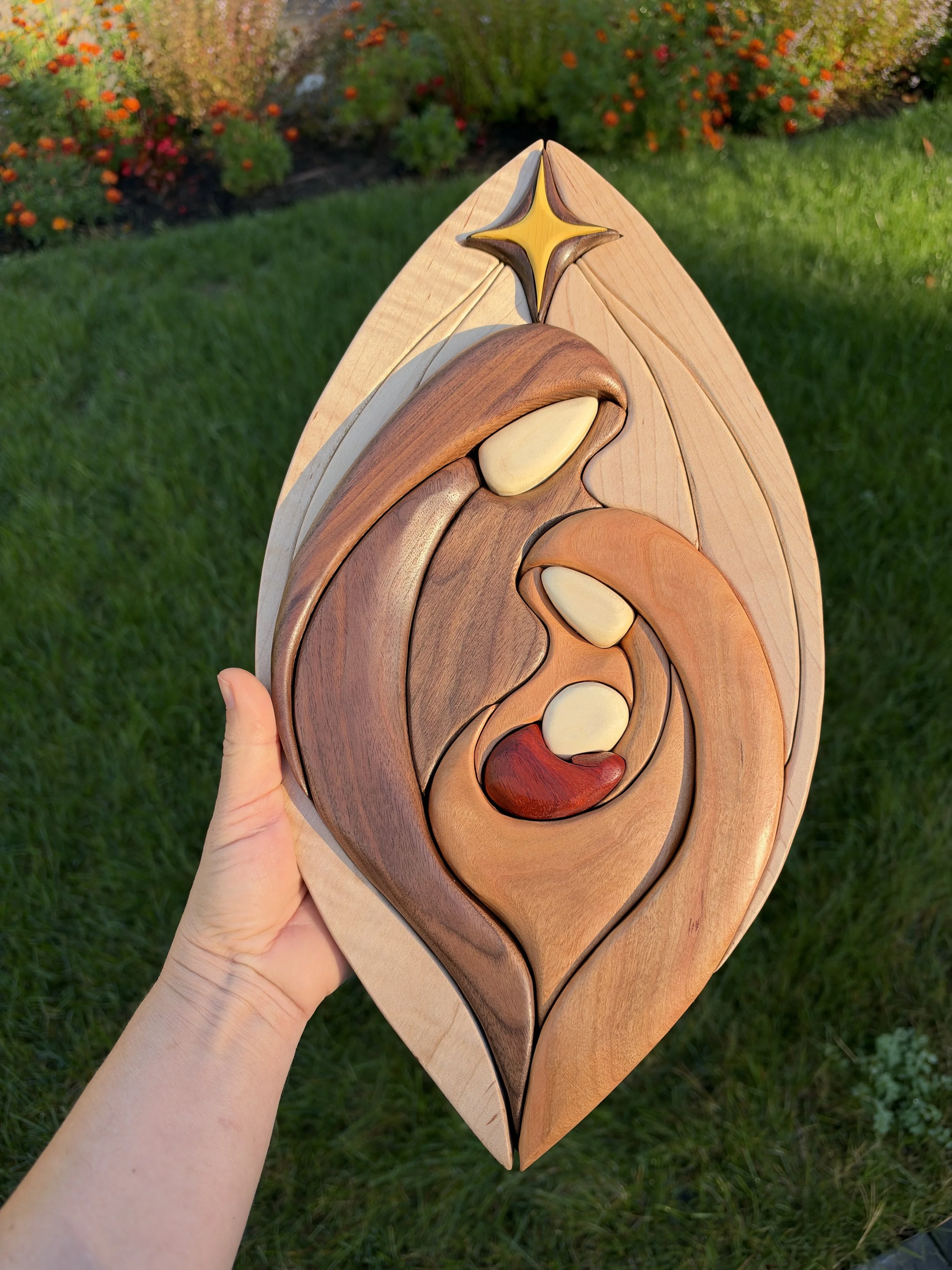 Full view of the natural wood nativity scene with a star above the Holy Family