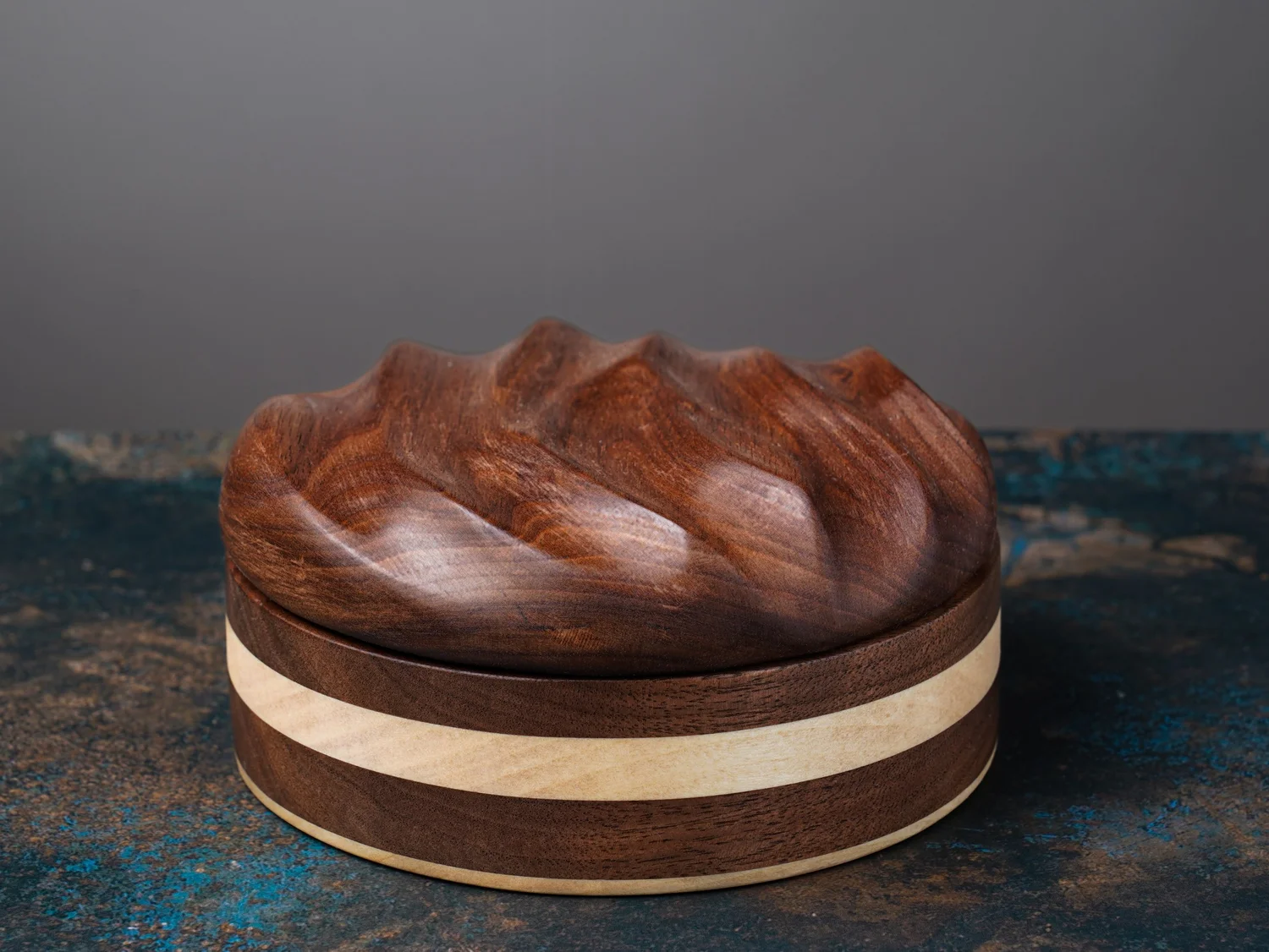 Round walnut keepsake box with sculpted lid and pale contrasting band