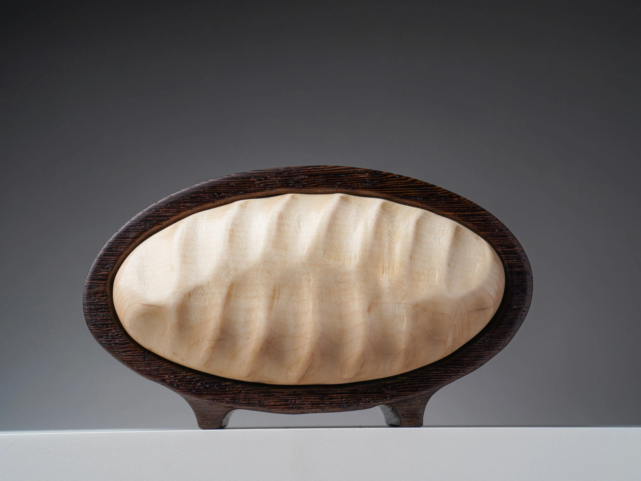 Wenge and curly maple keepsake box with a sculpted oval drawer front.