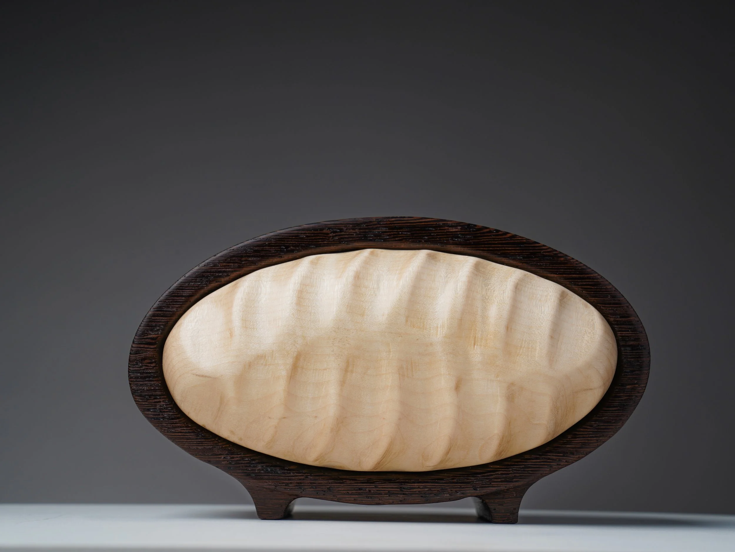 Oval bandsaw box showing the flowing hand-carved maple front.
