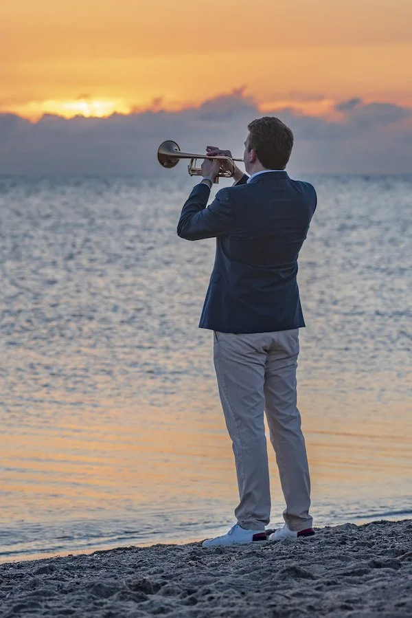 Ein Trompeter beim Sonnenaufgang.