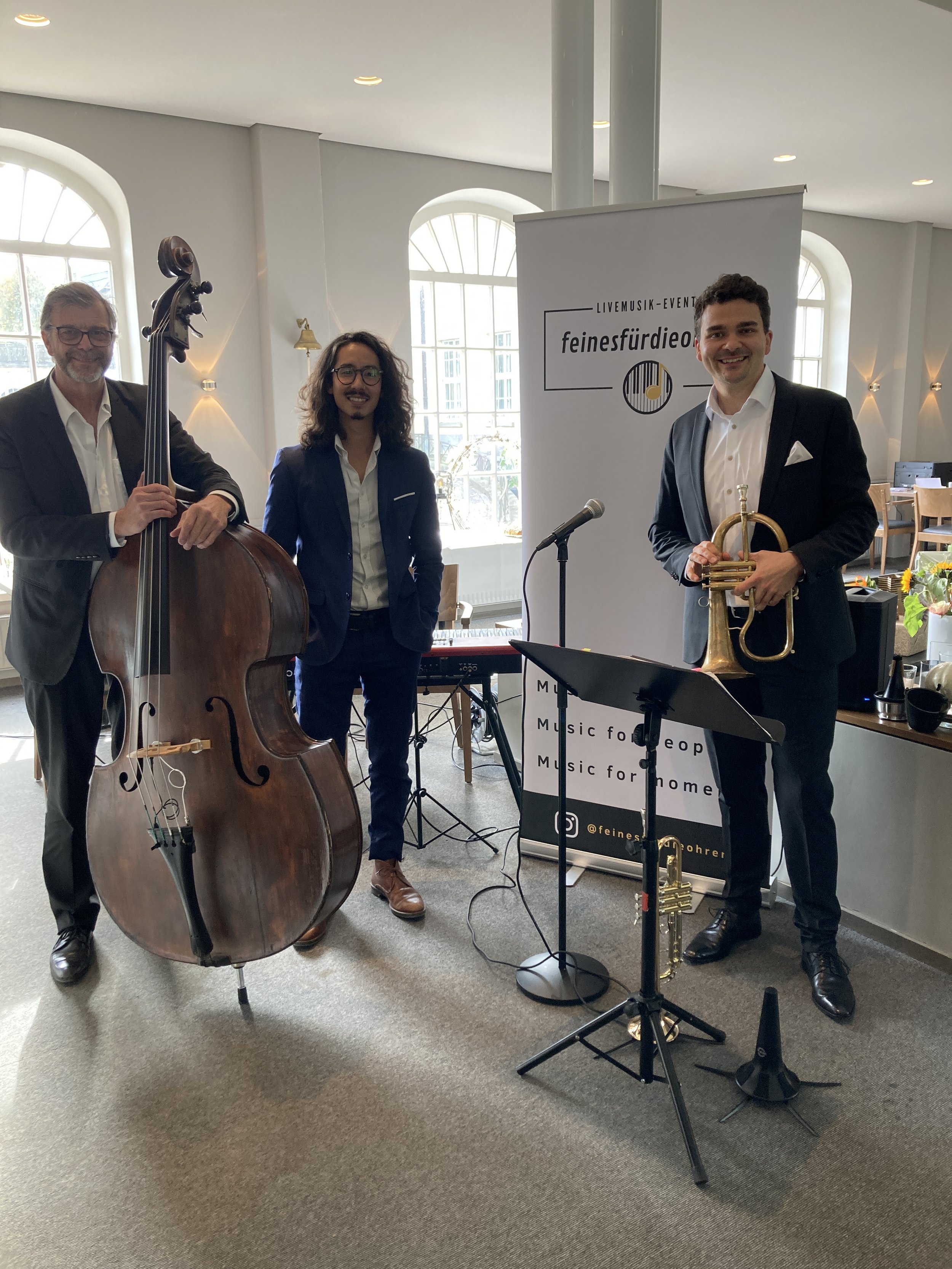 Musiker vor einem Roll-Up. 