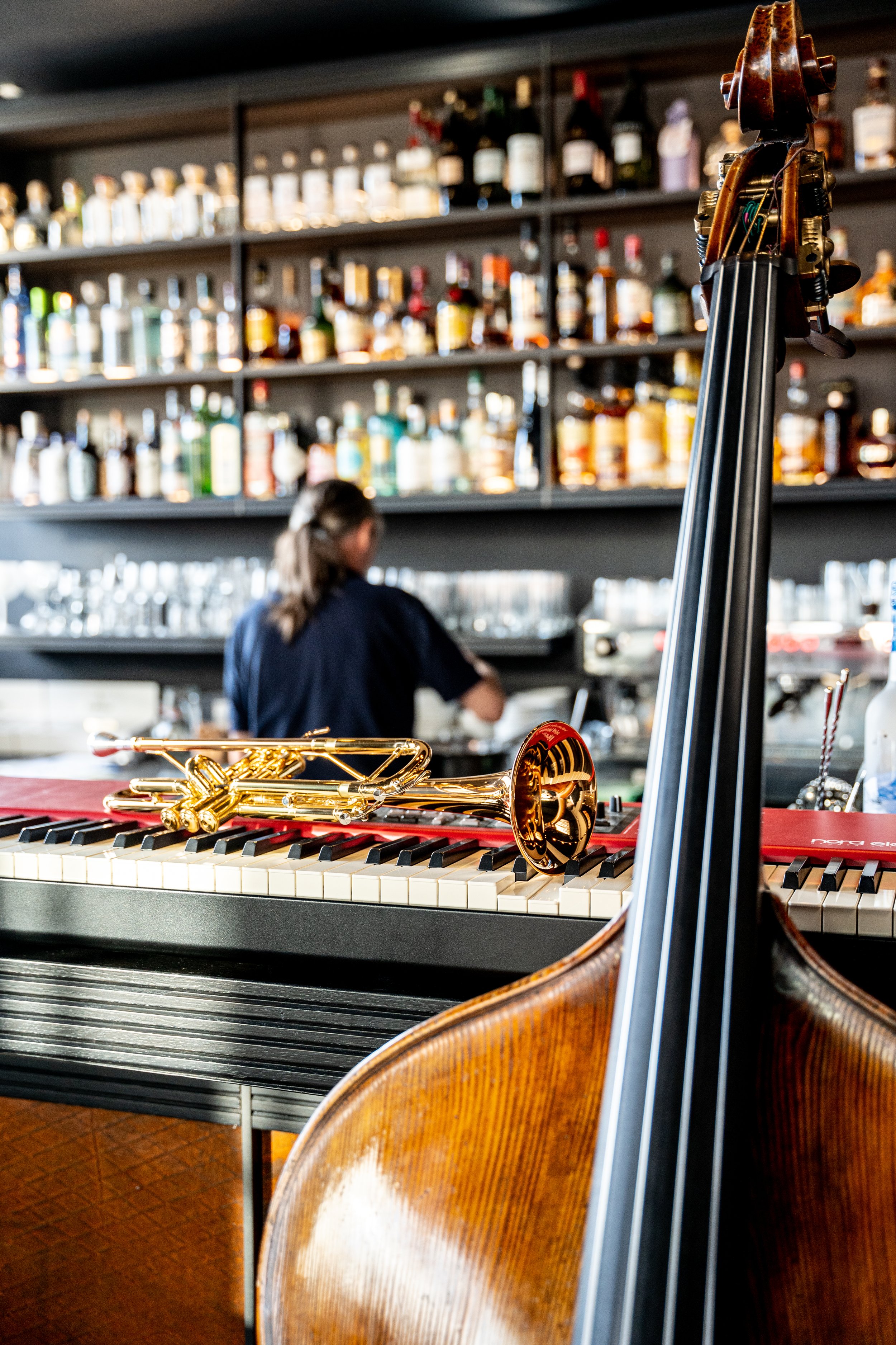 Ein Kontrabass und eine Trompete mit einem Klavier vor einer Bar