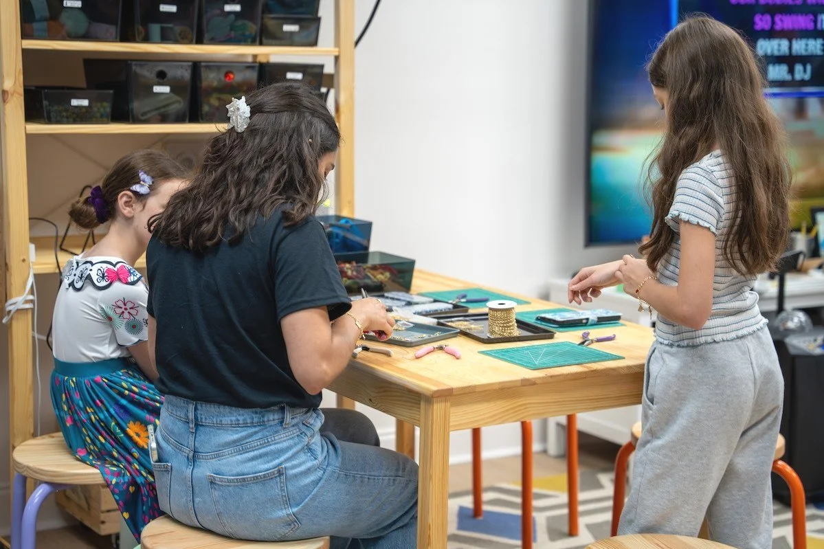 Kids and teens working on a creative project together at a Konekt Club event