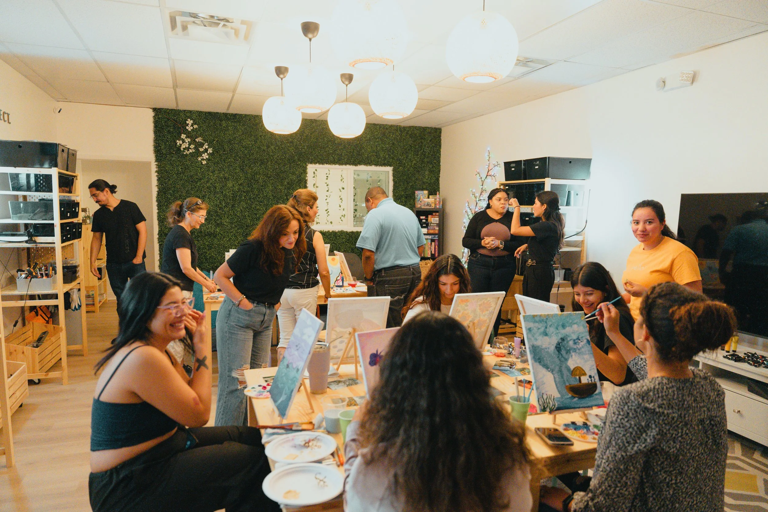 Adults laughing and painting on canvases at a paint and sip event at Konekt Club in Margate