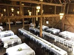 Empty dining area with long tables and chairs, set for a meal in a rustic wooden building known as Birchwood Venue in Milton, PA near Lewisburg, PA.