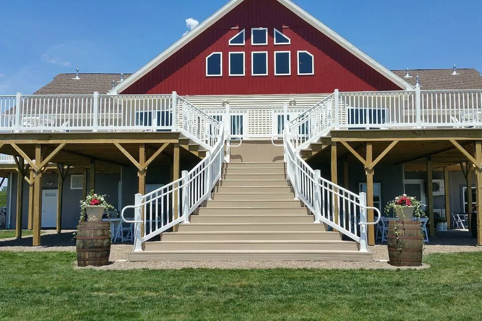 A red barn-style building with a steep roof and large windows at Whispering Oaks Vineyard in Sunbury, PA. Near Lewisburg, PA, and Selinsgrove PA.